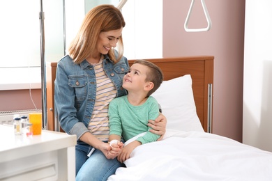 Photo of Woman visiting her little child with intravenous drip in hospital