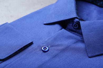 Photo of Closeup view of stylish blue shirt. Dry-cleaning service