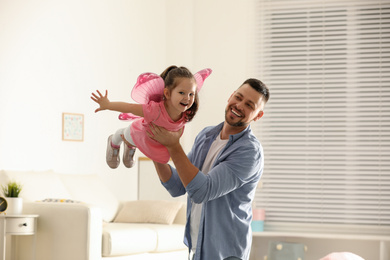 Photo of Father playing with his child at home