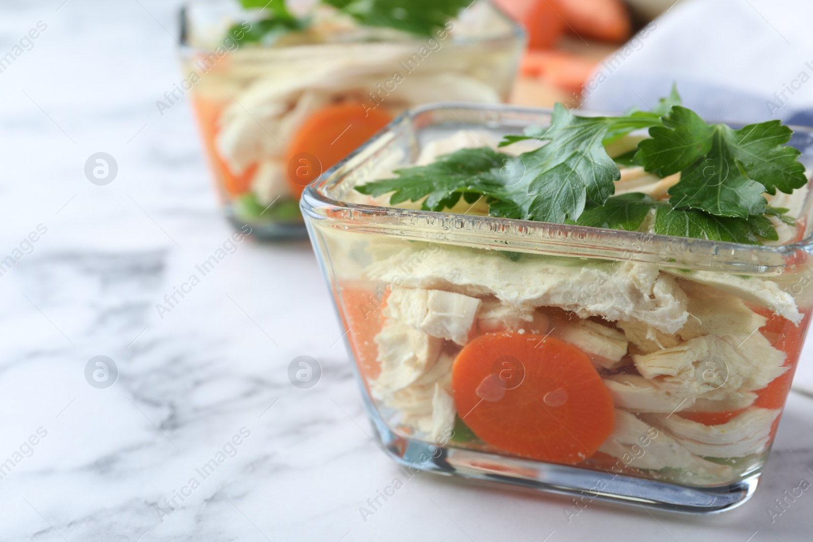 Photo of Delicious chicken aspic on white marble table, closeup. Space for text