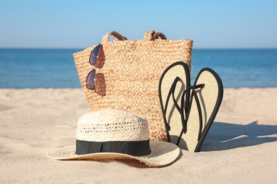 Photo of Stylish beach accessories on sandy sea shore