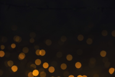 Photo of Beautiful golden lights on dark background. Bokeh effect
