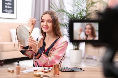 Photo of Beauty blogger recording makeup tutorial at home