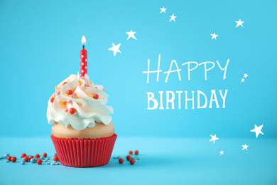 Image of Text Happy Birthday and delicious cupcake with candle on light blue background