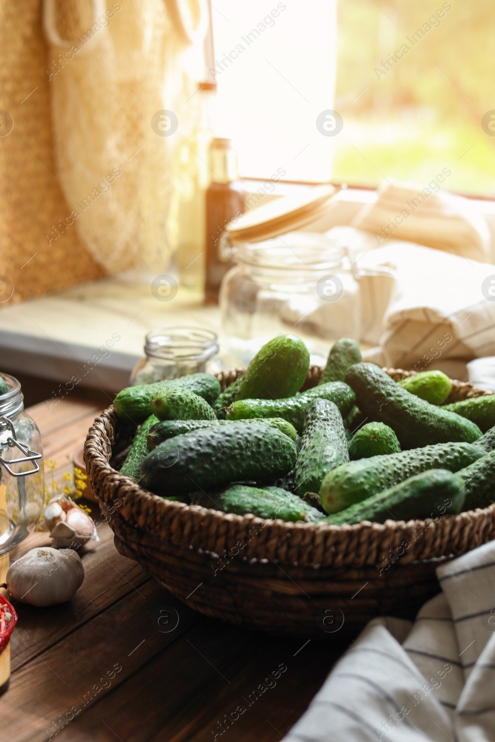 Photo of Fresh cucumbers and other ingredients on wooden table, closeup. Pickling vegetables