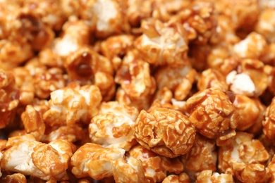 Photo of Sweet tasty caramel popcorn as background, closeup