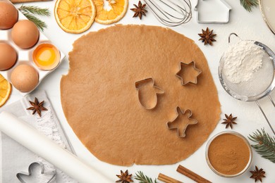 Photo of Flat lay composition with dough and cookie cutters on white table. Christmas biscuits