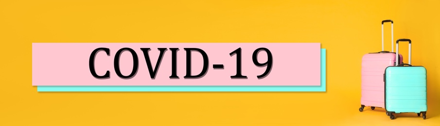 Image of Coronavirus pandemic, lockdown measures. Travel suitcases and text COVID-19 on yellow background, banner design