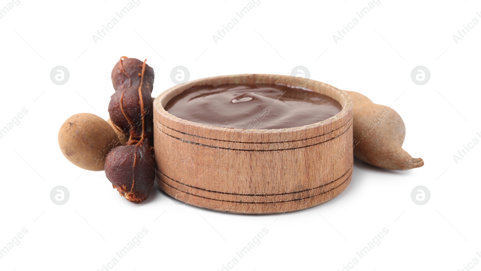 Bowl of tamarind sauce and fresh pods isolated on white Photo of Bowl of tamarind sauce and fresh pods isolated on white