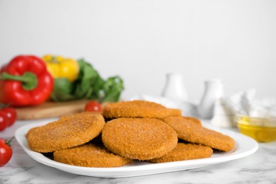 Photo of Delicious fried breaded cutlets on white marble table