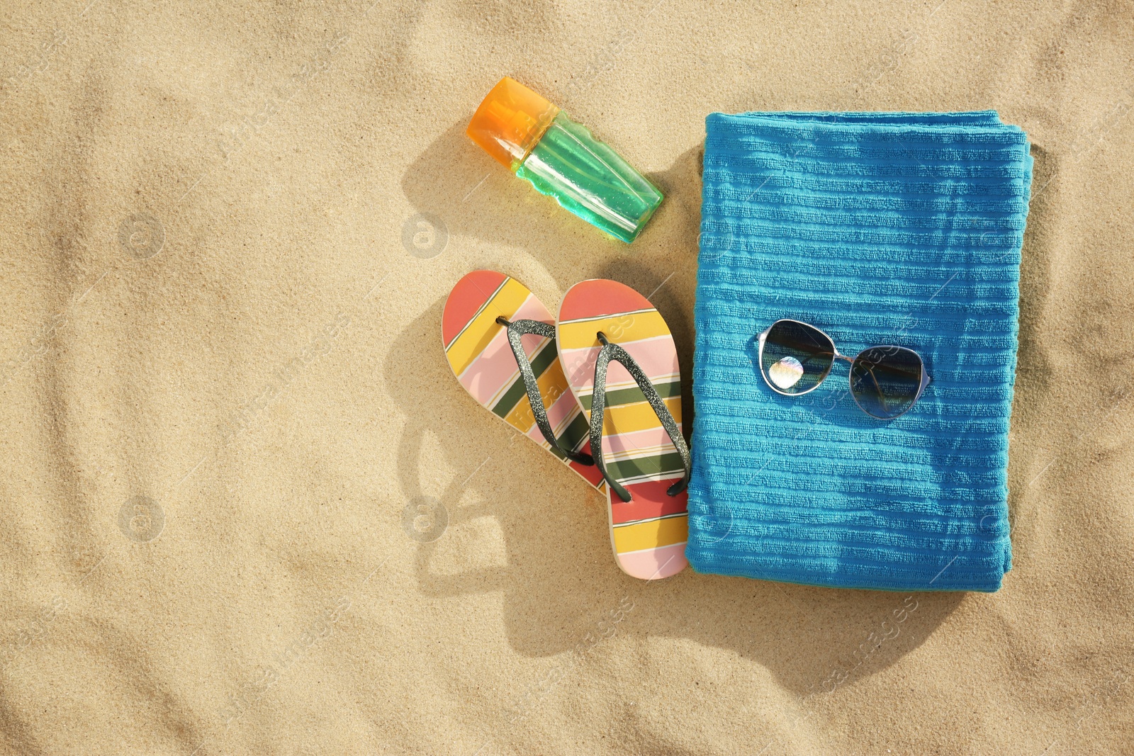 Photo of Flat lay composition of beach objects and towel on sand, space for text