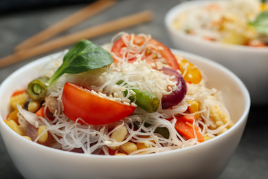 Photo of Tasty cooked rice noodles with vegetables on table, closeup