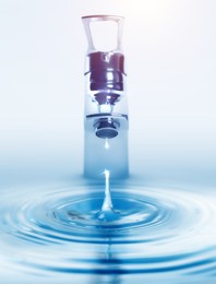 Image of Water dripping from tap with splash on light background