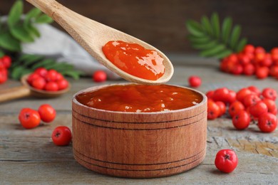 Photo of Delicious rowan jam in wooden bowl on table, closeup