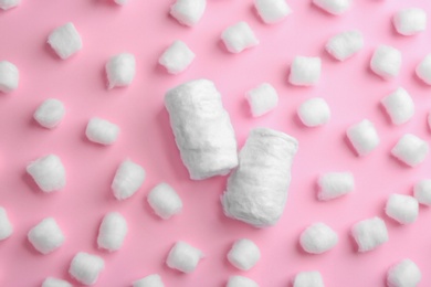 Photo of Flat lay composition with cotton balls and rolls on pink background