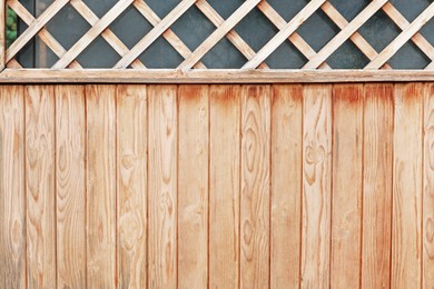 Photo of Texture of new wooden fence with lattice outdoors