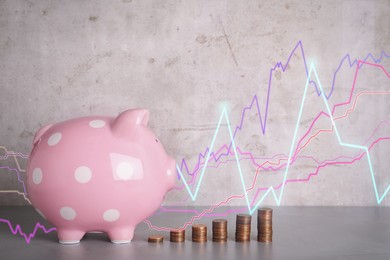 Image of Piggy bank and stacks of coins on grey table. Illustration of financial graphs