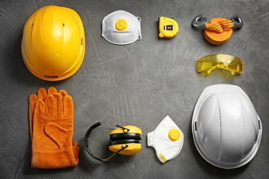Photo of Flat lay composition with safety equipment and space for text on grey background