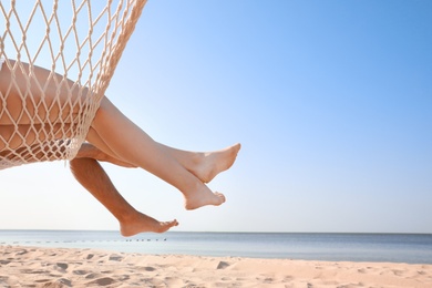Photo of Young couple relaxing in hammock on beach, closeup