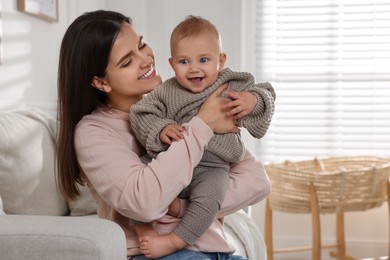 Photo of Happy young mother with her baby in living room