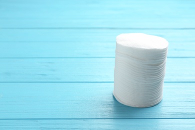 Photo of Stack of cotton pads on wooden background. Space for text