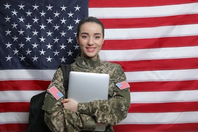 Female soldier with backpack and laptop near flag of United States. Military education