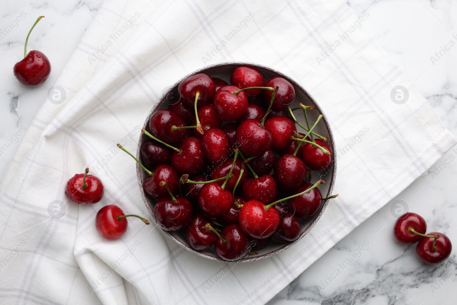 Photo of Fresh ripe cherries with water drops on white marble table, flat lay