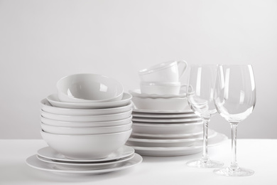 Photo of Set of clean dishes on white table