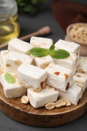 Pieces of delicious nutty nougat on wooden board, closeup