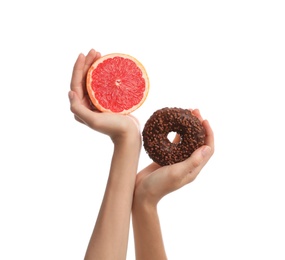 Photo of Woman choosing between doughnut and fresh grapefruit on white background, closeup