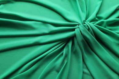 Photo of Beautiful green tulle fabric as background, top view