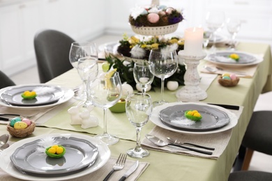 Photo of Beautiful Easter table setting with burning candles indoors