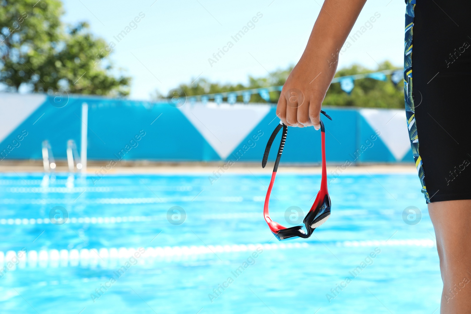 Photo of Swimmer with goggles near outdoor pool, closeup. Space for text