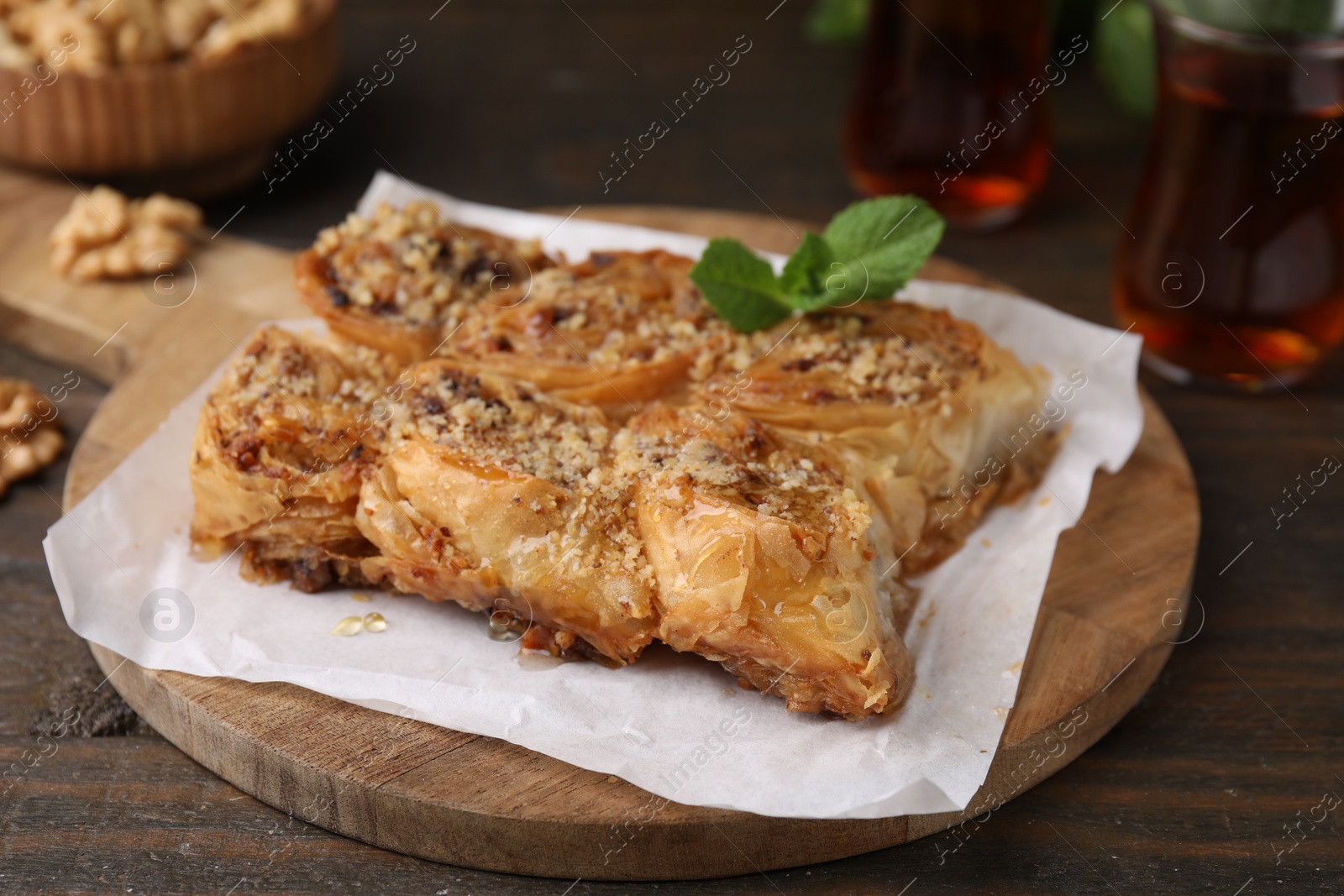 Photo of Eastern sweets. Pieces of tasty baklava on wooden table, closeup