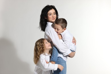 Photo of Little children with their mother on white background