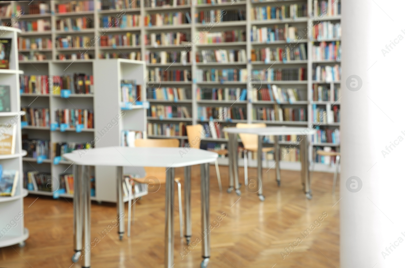 Photo of Blurred view of bookshelves and tables in library