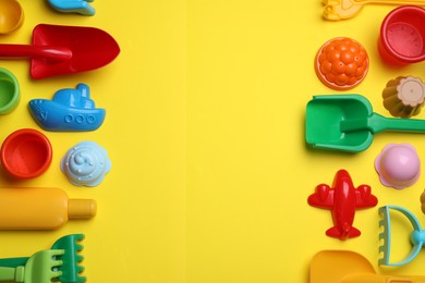 Photo of Beach sand toys on yellow background, flat lay. Space for text