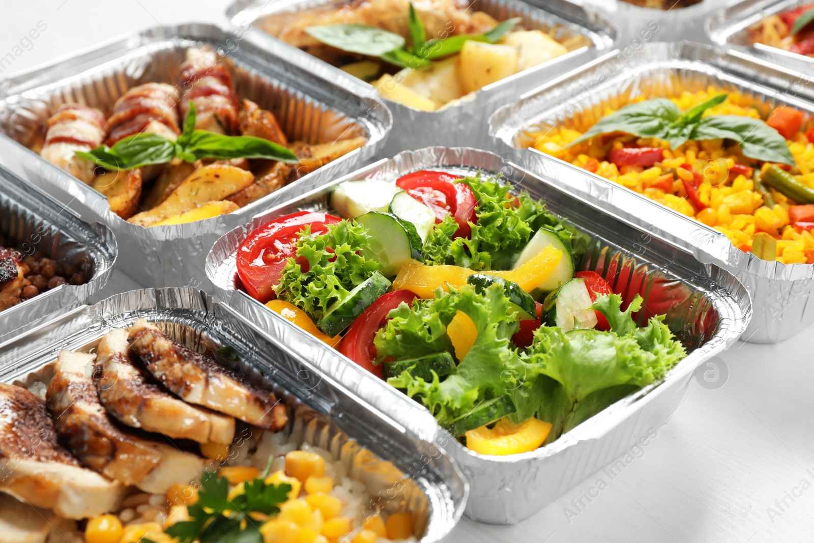 Photo of Lunchboxes on white wooden table, closeup. Healthy food delivery