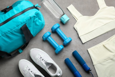 Flat lay composition with gym bag and sportswear on grey table