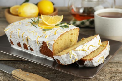 Photo of Tasty lemon cake with glaze on wooden table, closeup