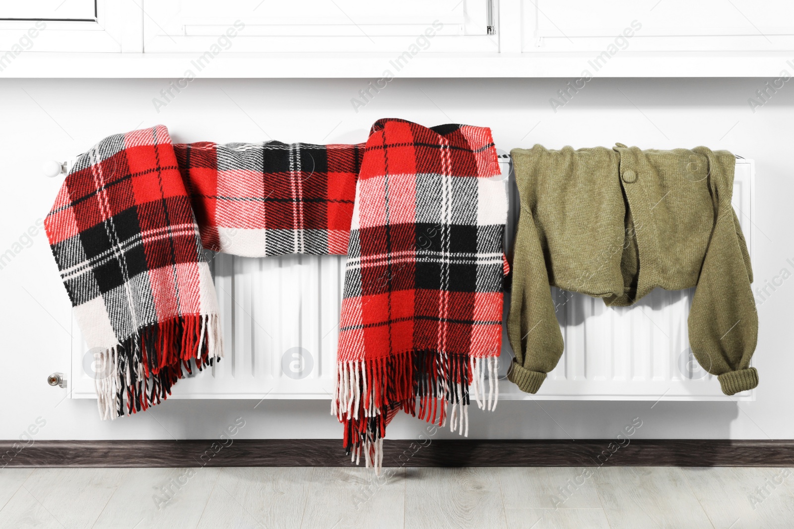 Photo of Clothes hanging on white radiator in room