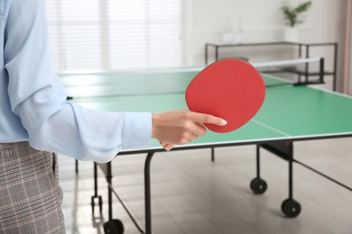 Photo of Business with tennis racket near ping pong table in office, closeup