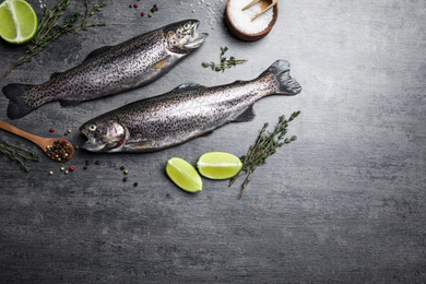 Flat lay composition with raw cutthroat trout fish on grey table