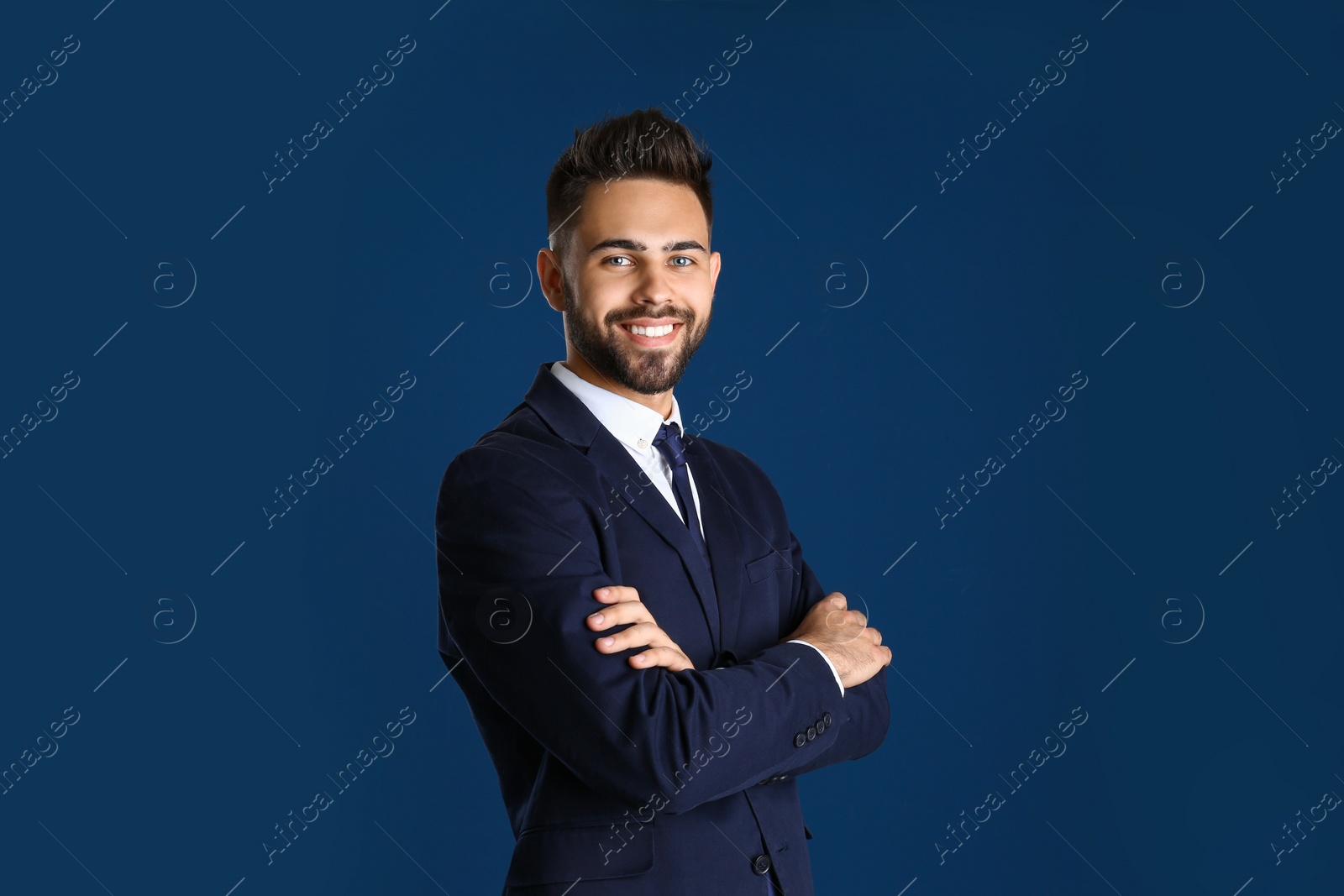 Photo of Portrait of handsome smiling man in office suit on color background