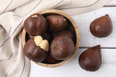 Photo of Fresh salak fruits in bowl on white wooden table, top view