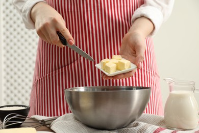 Photo of Woman adding fresh butter into bowl at table, closeup