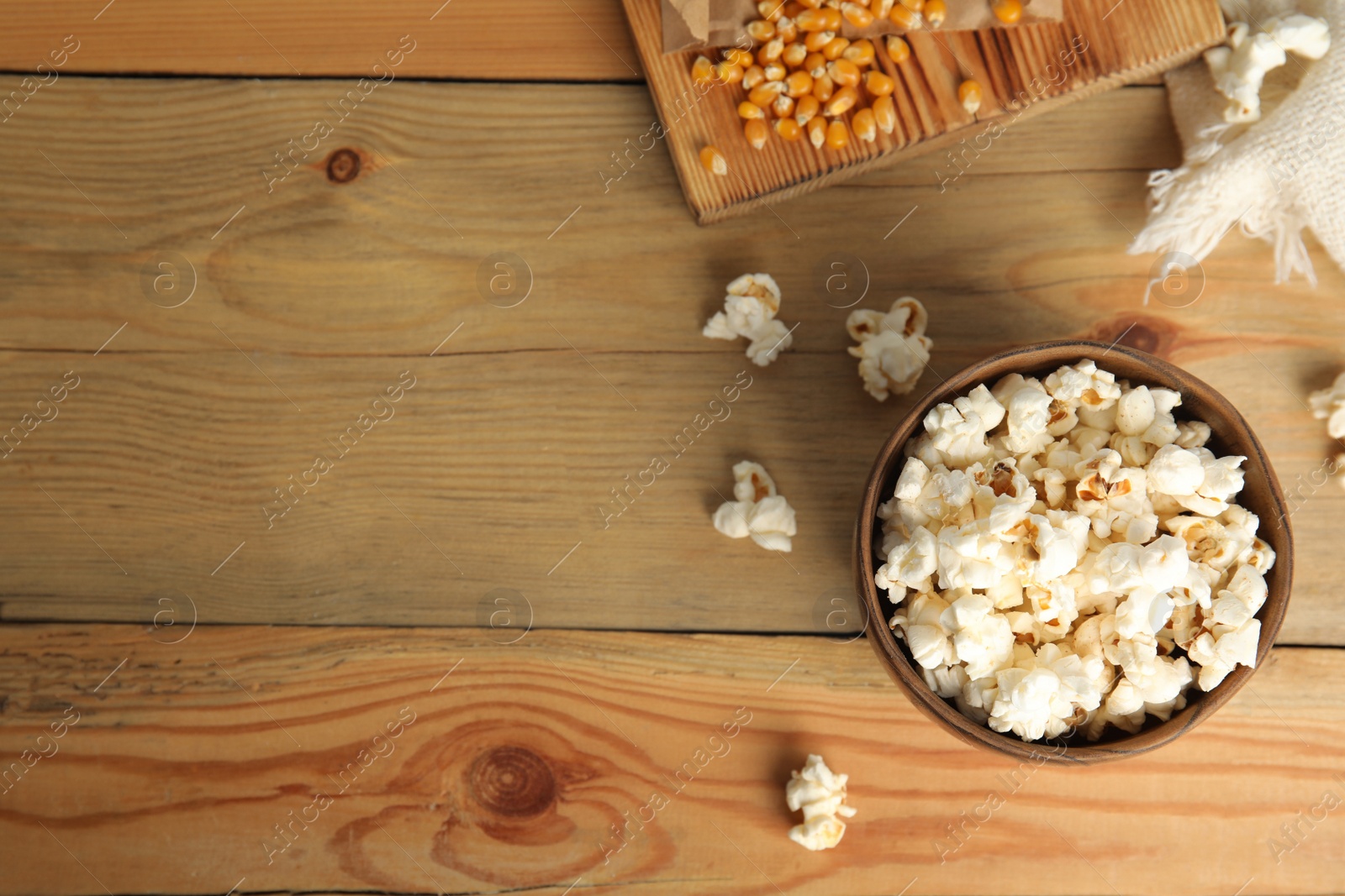 Photo of Tasty pop corn on wooden table, flat lay. Space for text