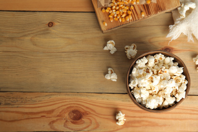 Photo of Tasty pop corn on wooden table, flat lay. Space for text