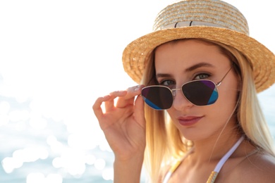 Photo of Beautiful woman wearing sunglasses near sea on sunny day