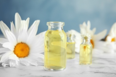 Photo of Composition with essential oil and flowers on table